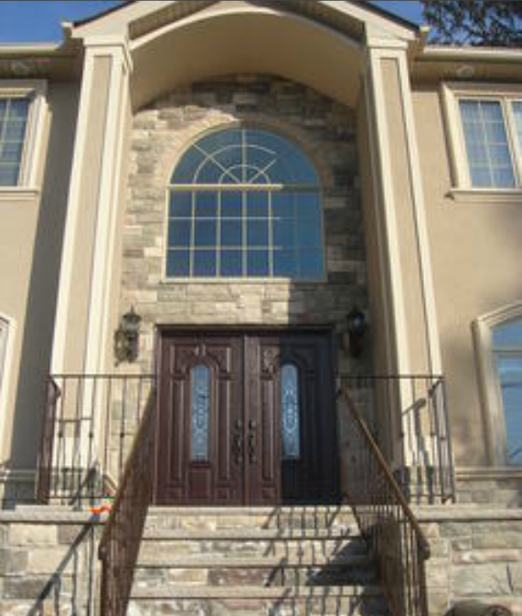 stucco house front with decorative stone front and stairway