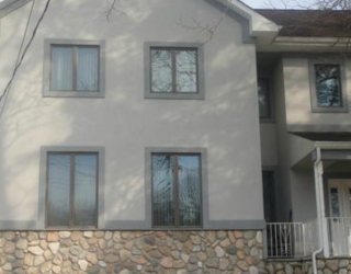 tan stucco house front with stone bottom lining