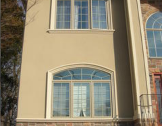 tan stucco house from with stone bottom lining