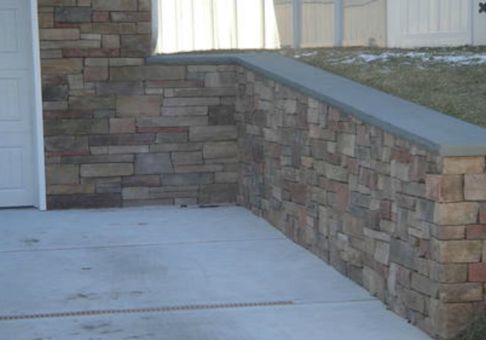 driveway with stone wall lining installed by pavers