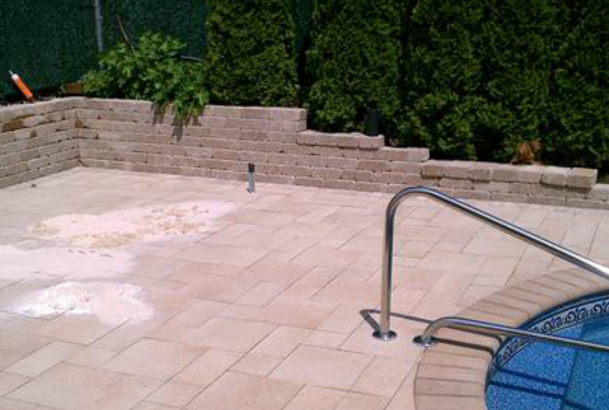 stone ground and wall installed by pool in backyard