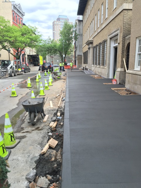 concrete pouring and paved by pavers near commercial building