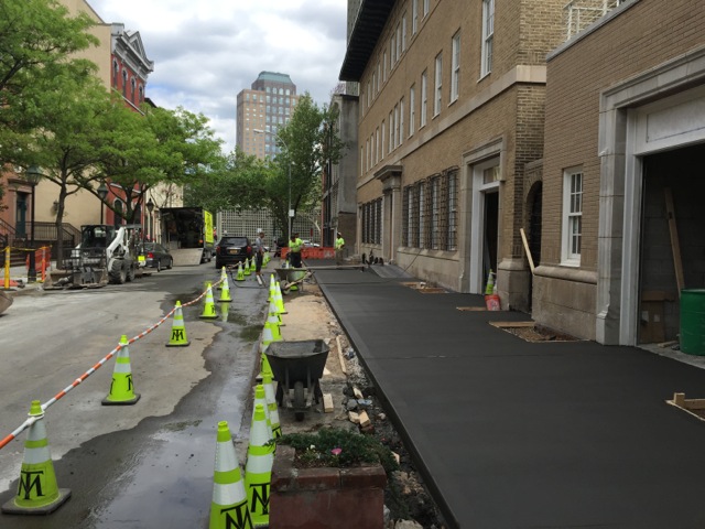 new sidewalk being paved near commercial building