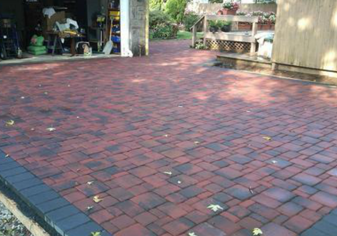 Backyard with brick flooring installed by pavers